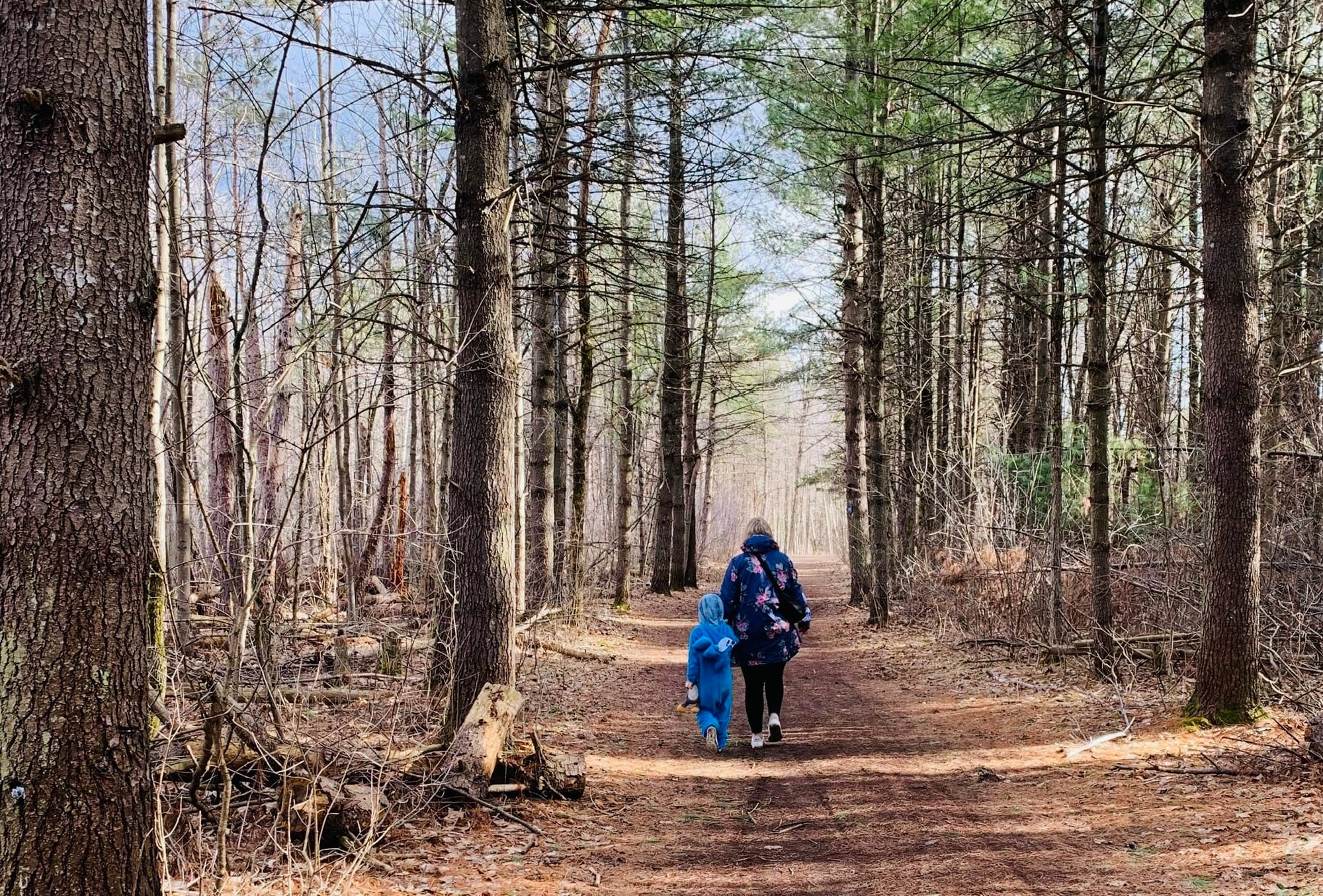 mother and child walk through woods 